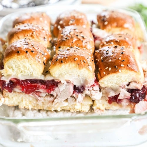 A pan of turkey sliders with cranberry sauce.