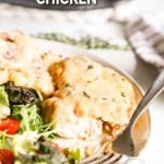 Smothered chicken breast on plate with fork and salad