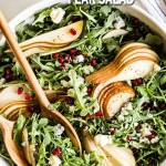 overhead of a salad bowl filled with arugula salad with pears.