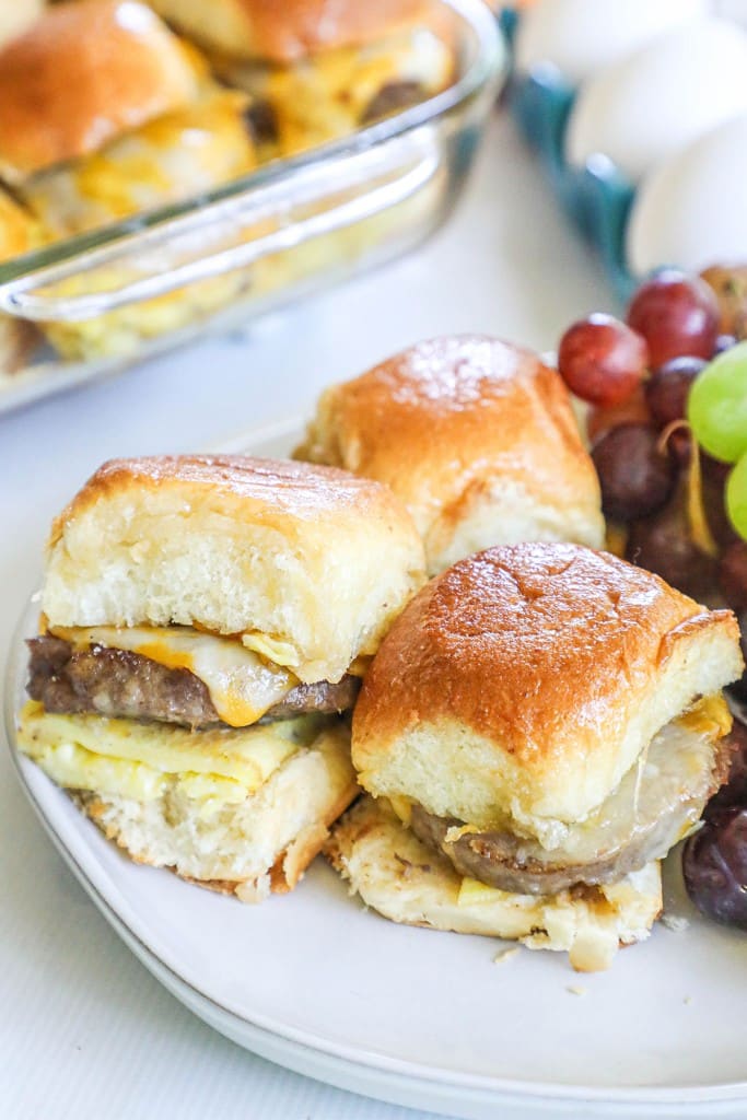 Breakfast Sliders with Sausage, agg and cheese. Grapes are next to the sliders.