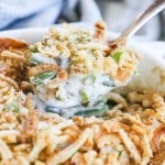 Green Bean Casserole being scooped out of a white baking dish