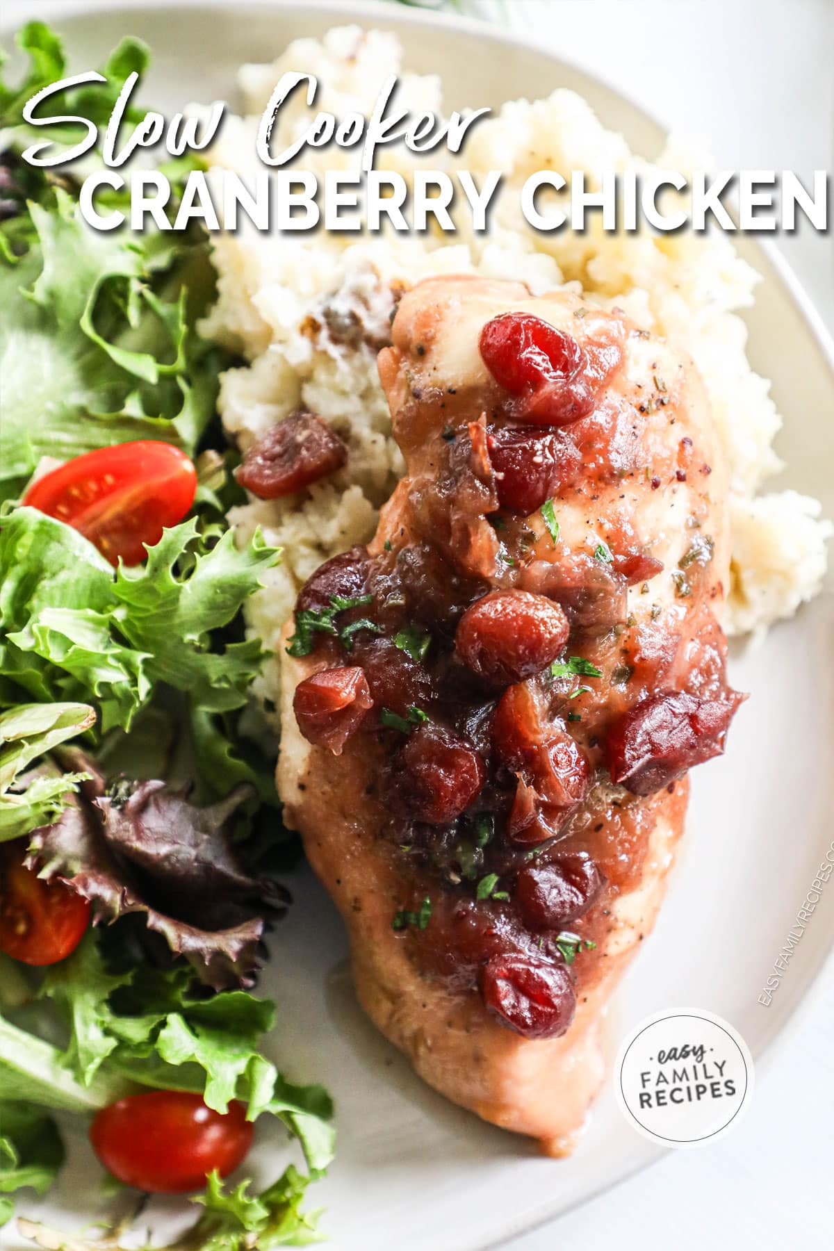 Slow cooker cranberry orange chicken on a plate with sides.