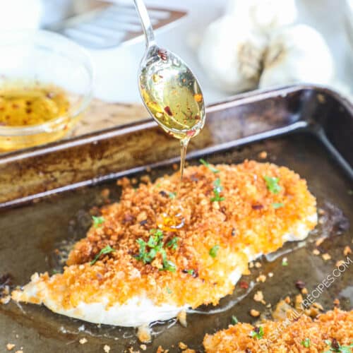 Baked Panko Chicken being drizzled with honey.