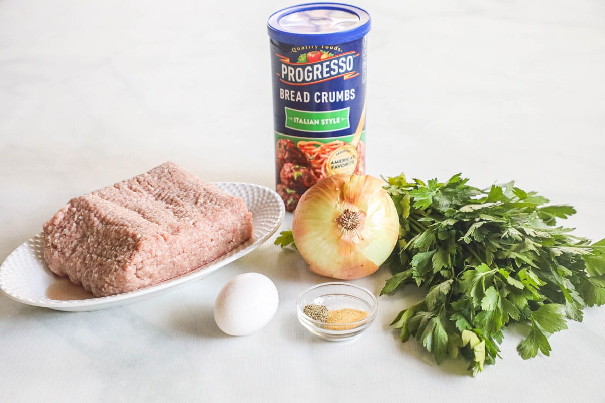 Ingredients for ground turkey patties, including seasonings, onion, parsley, ground turkey, egg, and breadcrumbs