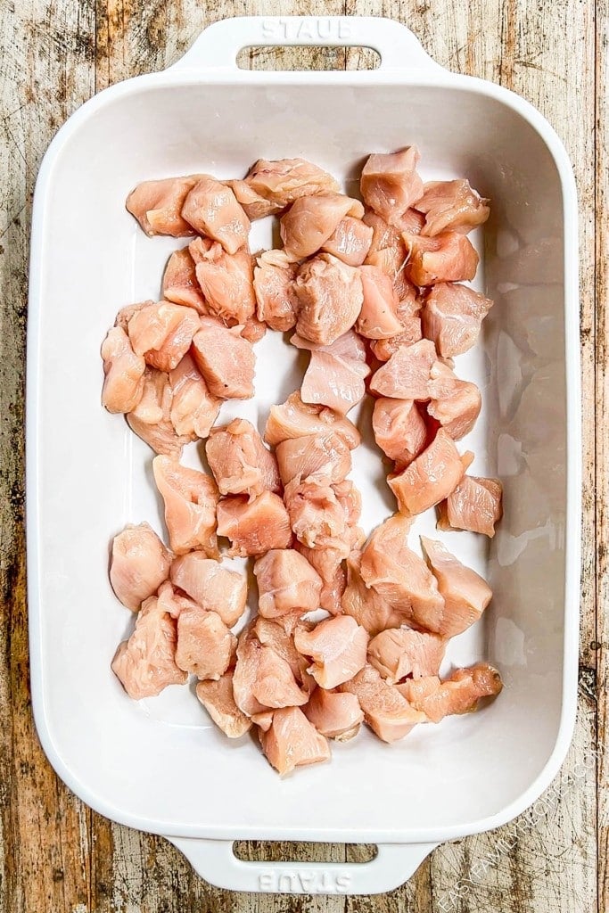 Overhead view of raw chicken bites in baking dish