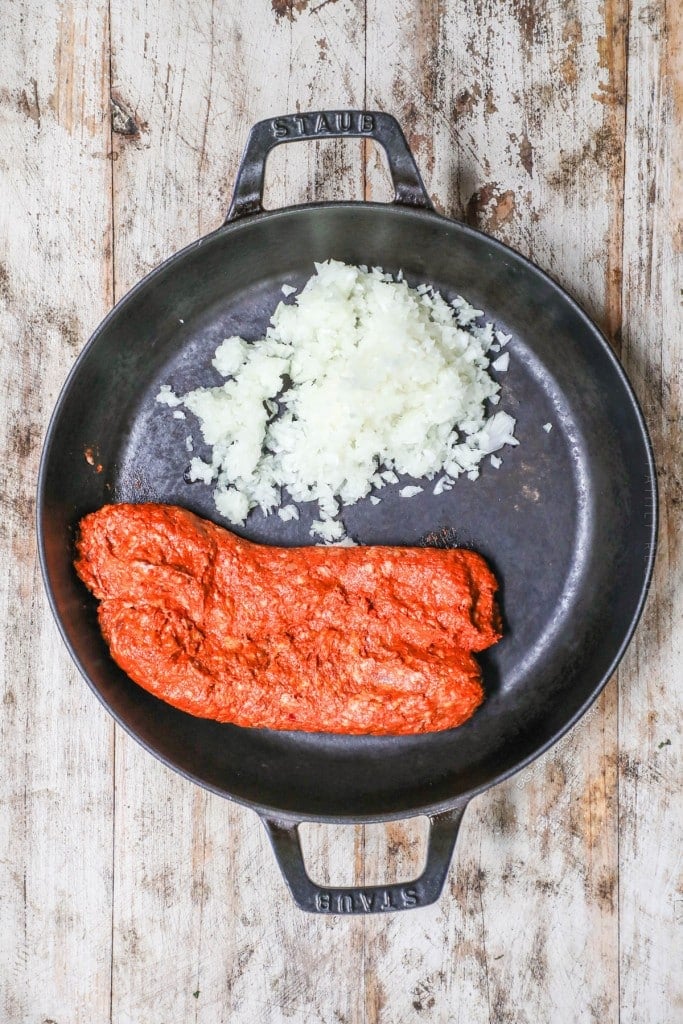 Overhead view of chorizo and onion in cast iron skillet