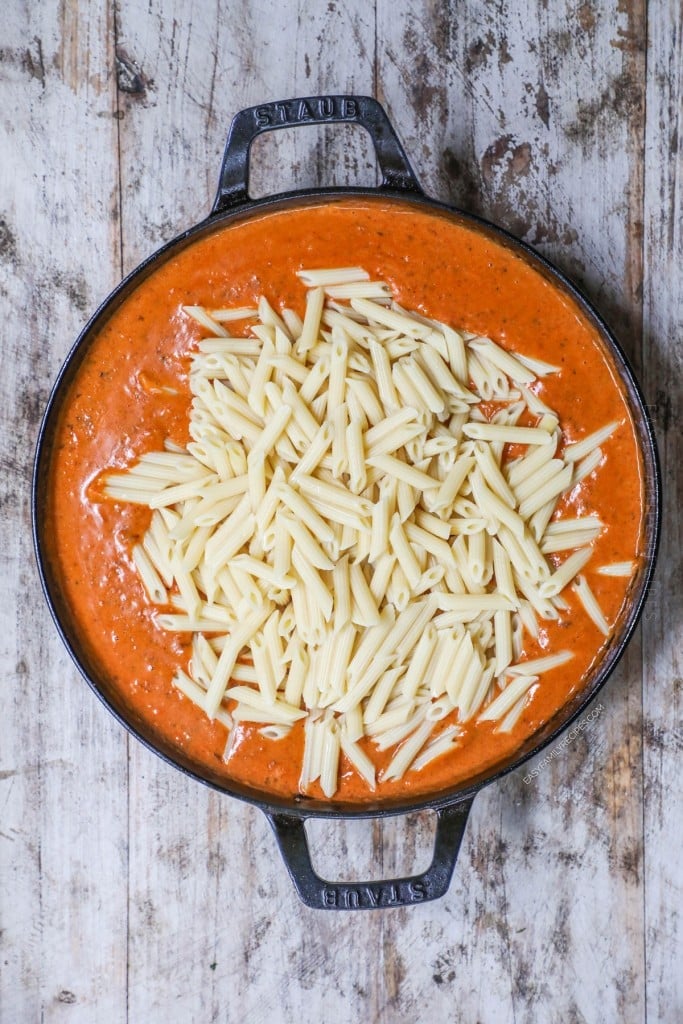 Overhead view of pasta added to creamy chorizo sauce