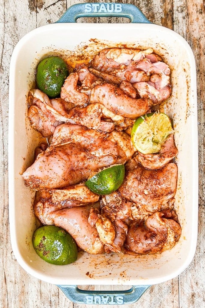Marinating Mexican chicken thighs in pan with limes