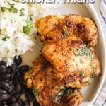 Mexican style chicken thighs on plate with rice and beans