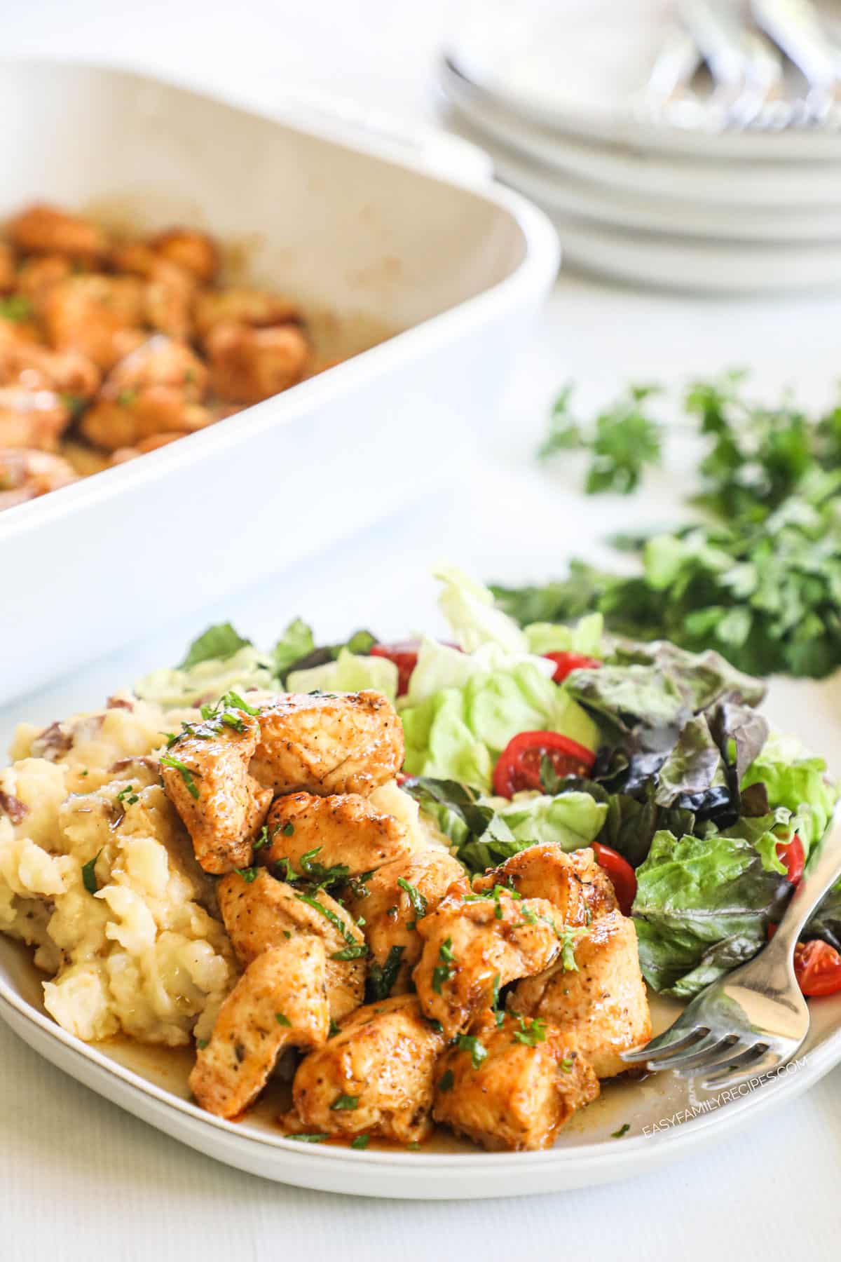 Chicken bites on plate with salad and fork