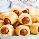 Stack of crescent roll pigs in a blanket on white plate