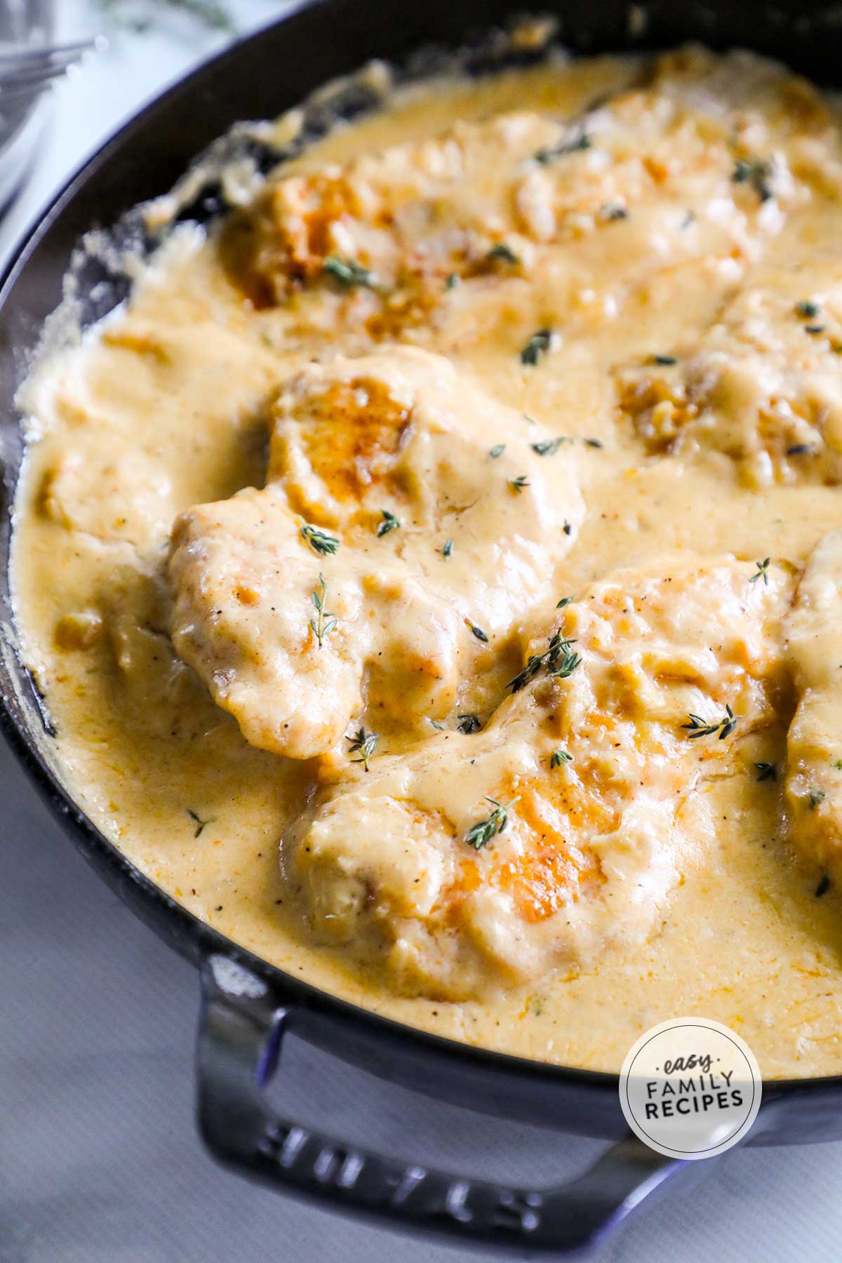 Smothered chicken breasts in skillet with creamy gravy