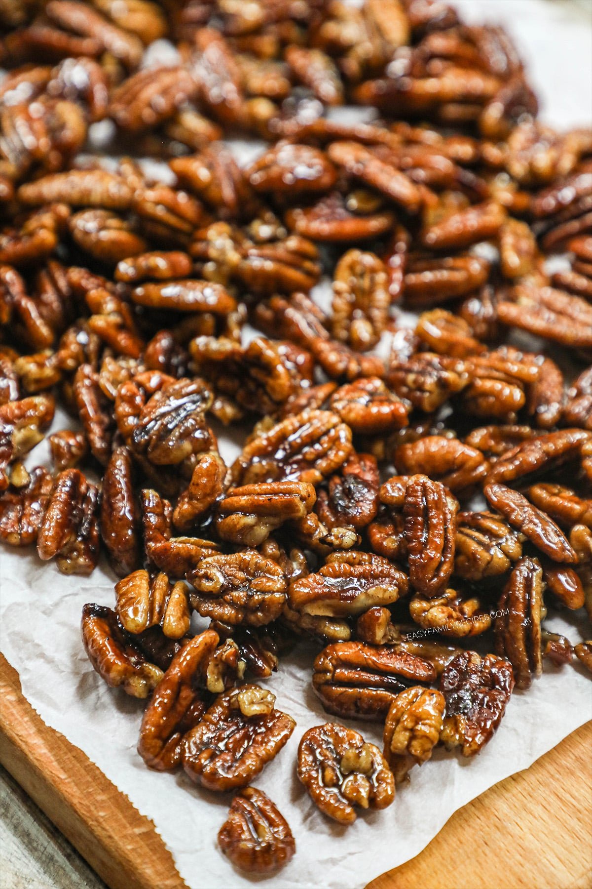 overhead image of sweet and spicy pecans spread out on a piece of parchment paper.