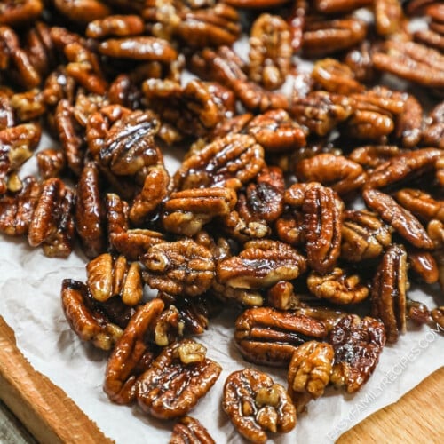 overhead image of sweet and spicy pecans spread out on a piece of parchment paper.