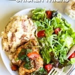 Overhead view of Tuscan chicken thighs on plate with spinach and mashed potatoes