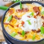 Big bowl of baked potato soup topped with green onions, bacon, cheese, and sour cream.