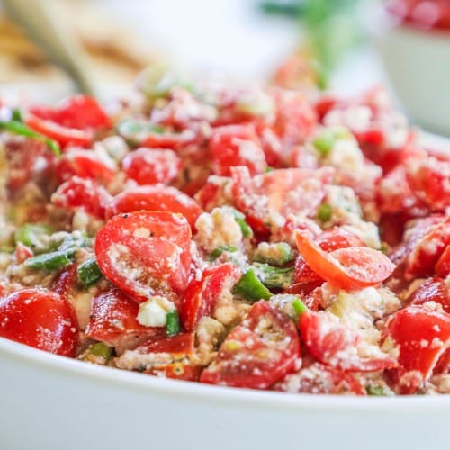 side view of a bowl filled with cherry tomato feta dip.