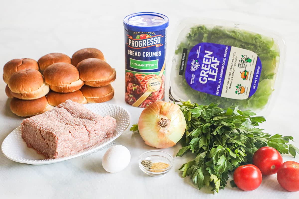 Ingredients to make turkey burger sliders including ground turkey, breadcrumbs, egg, onion, tomatoes, lettuce, and cheese.