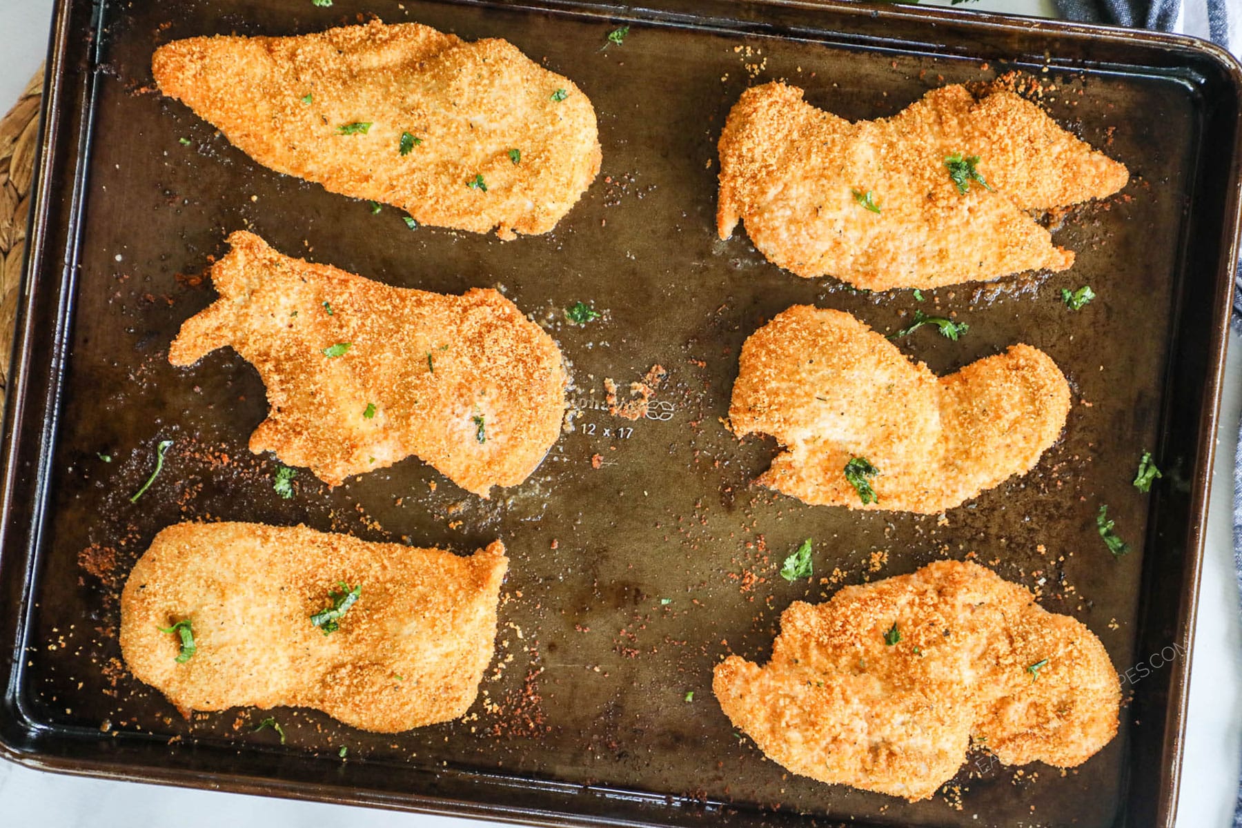 Homemade Shake and bake chicken on a baking sheet.