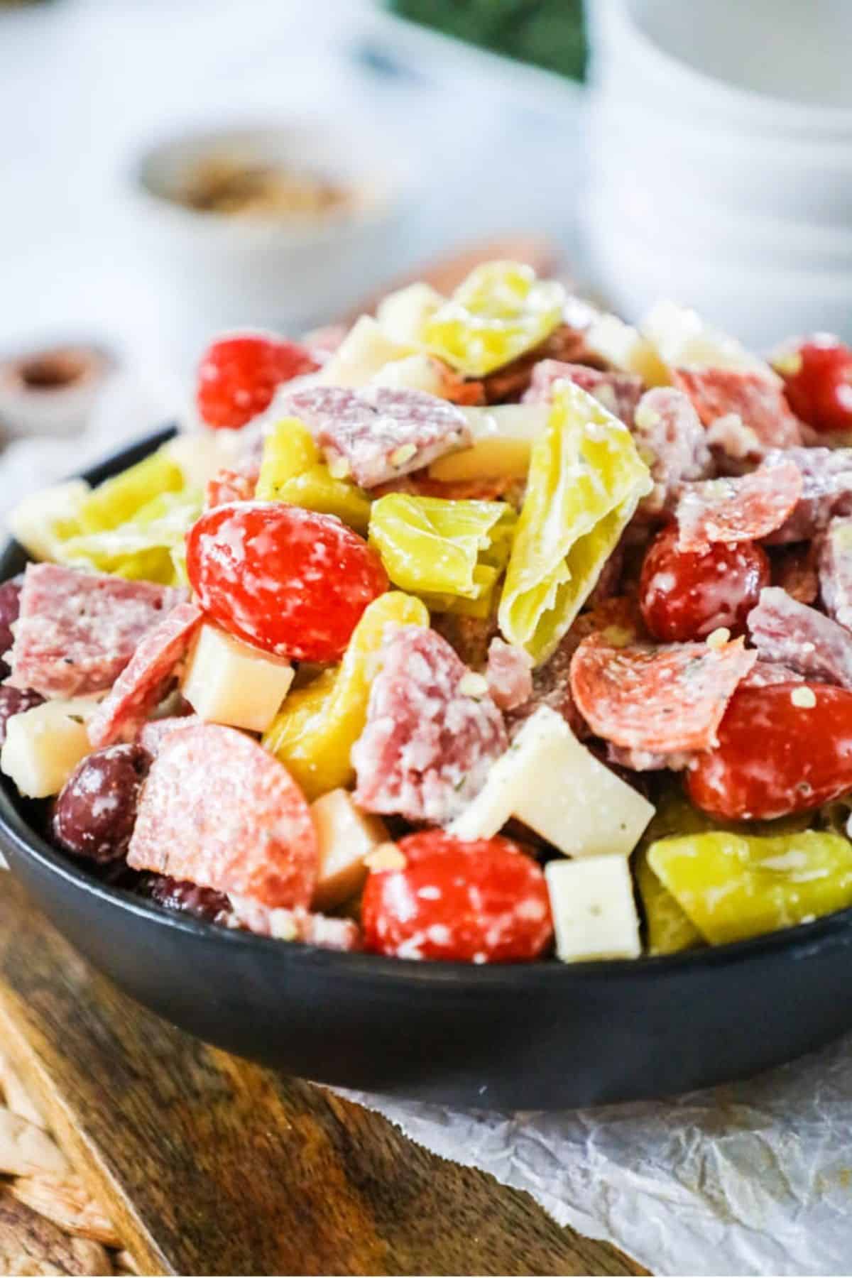antipasto in a bowl with tomatoes, meats and peppers
