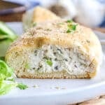 Close up of a chicken pillow cut in half so you can see the creamy, cheesy chicken filling