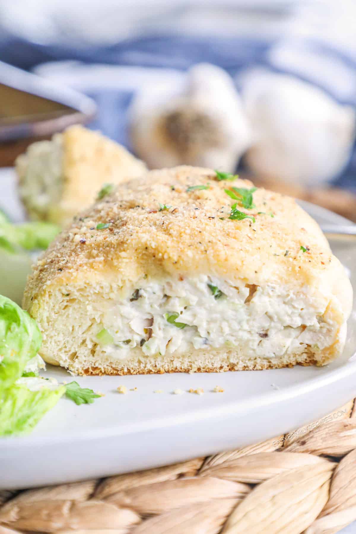Close up of a chicken pillow cut in half so you can see the creamy, cheesy chicken filling