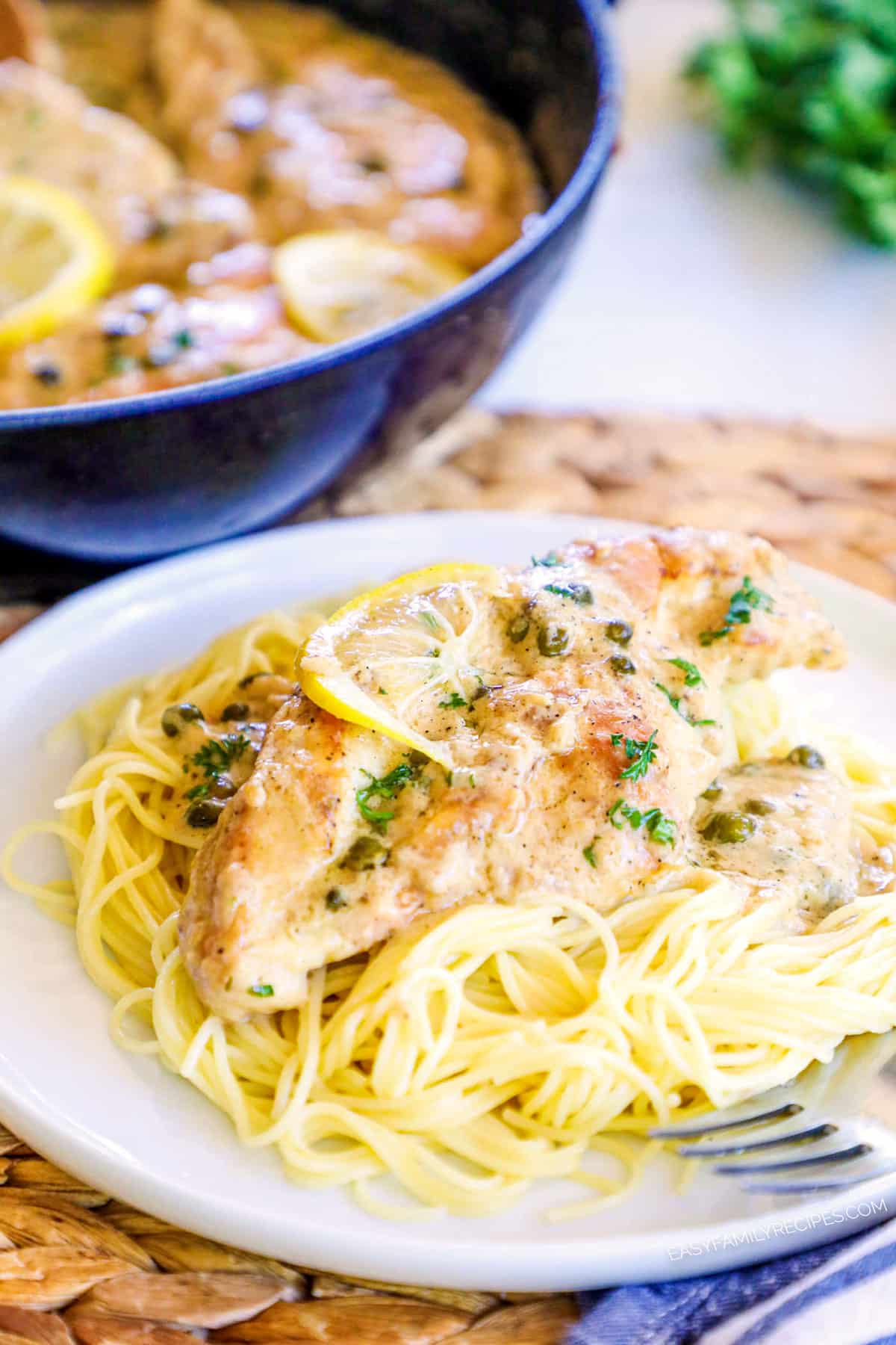 Creamy Chicken Piccata on a plate and garnished with Lemon and parsley.