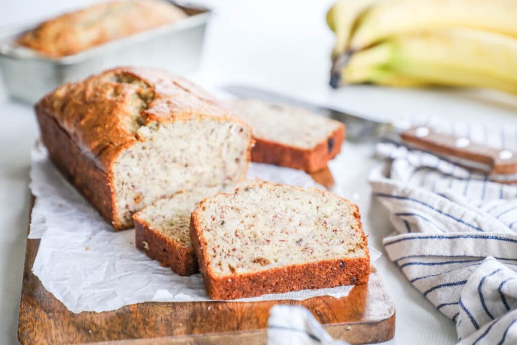 Banana bread cut into slices and arranged on a board ready to eat.