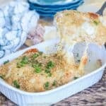 Chicken cordon bleu casserole being lifted from serving dish to plate.