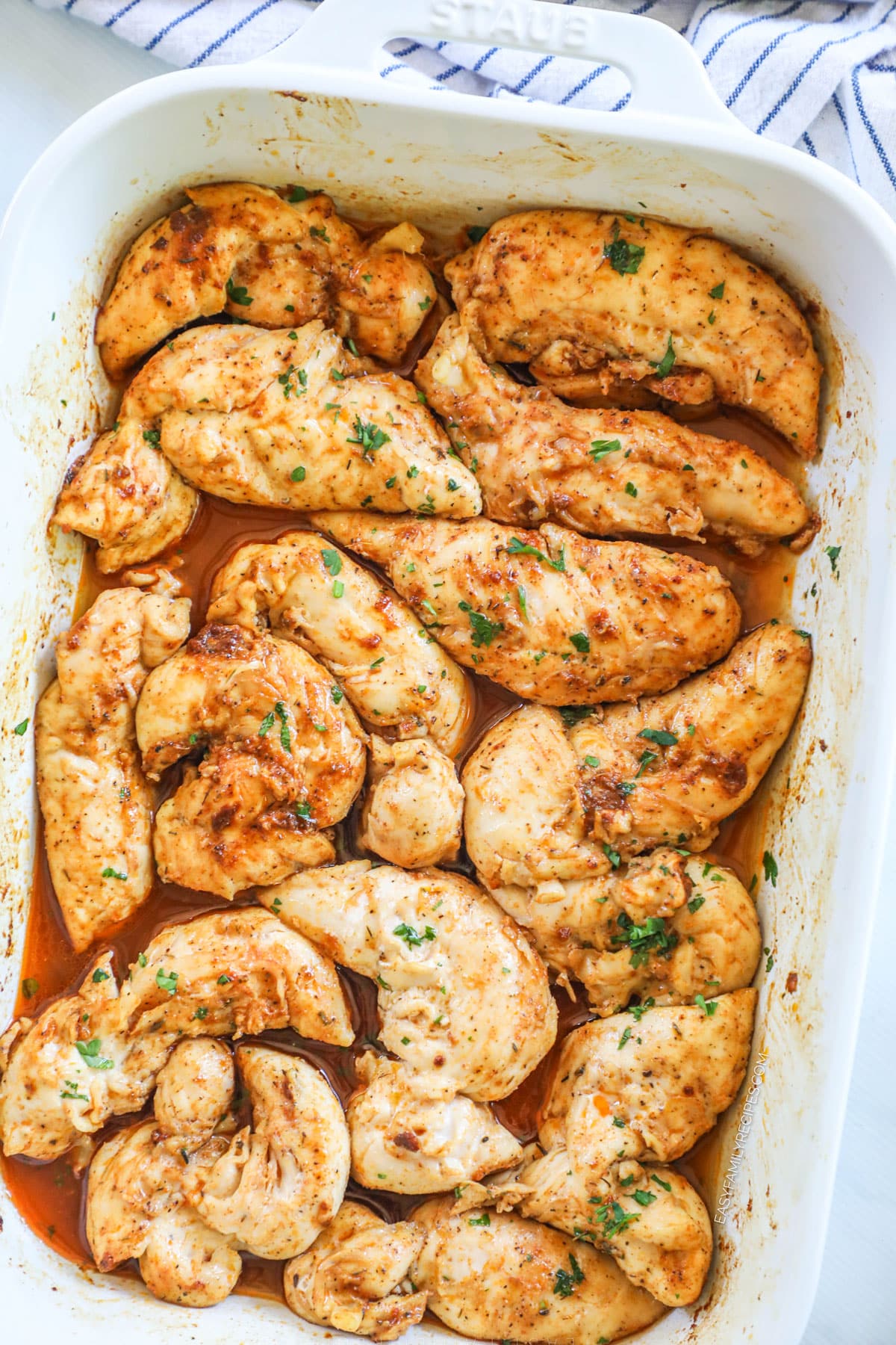 Oven baked chicken tenders with no breading in a white casserole dish