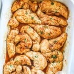 Oven baked chicken tenders with no breading in a white casserole dish