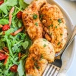 Oven-baked chicken tenders on a plate served with a garden salad.