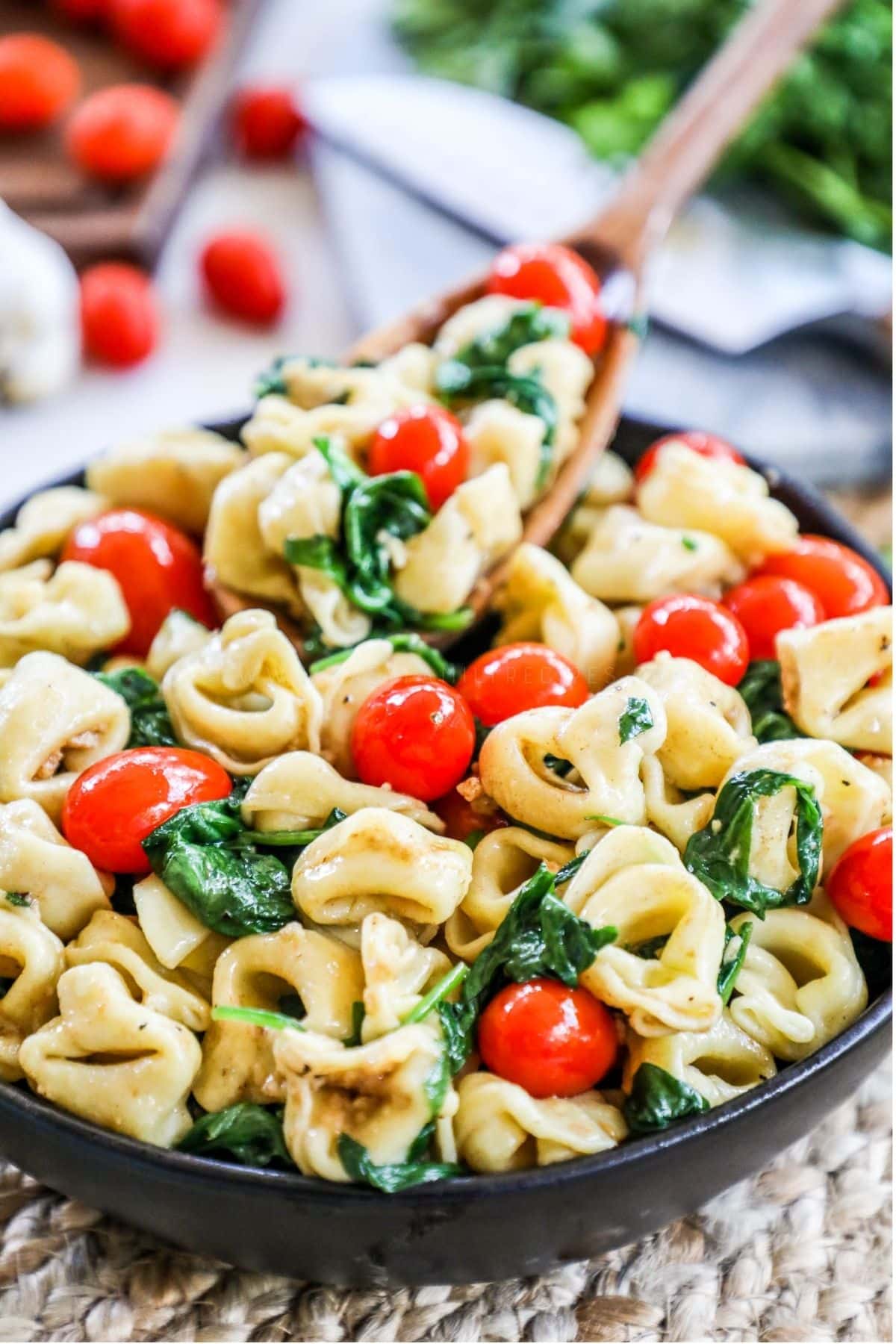 spinach and tomato tortellini in a skillet