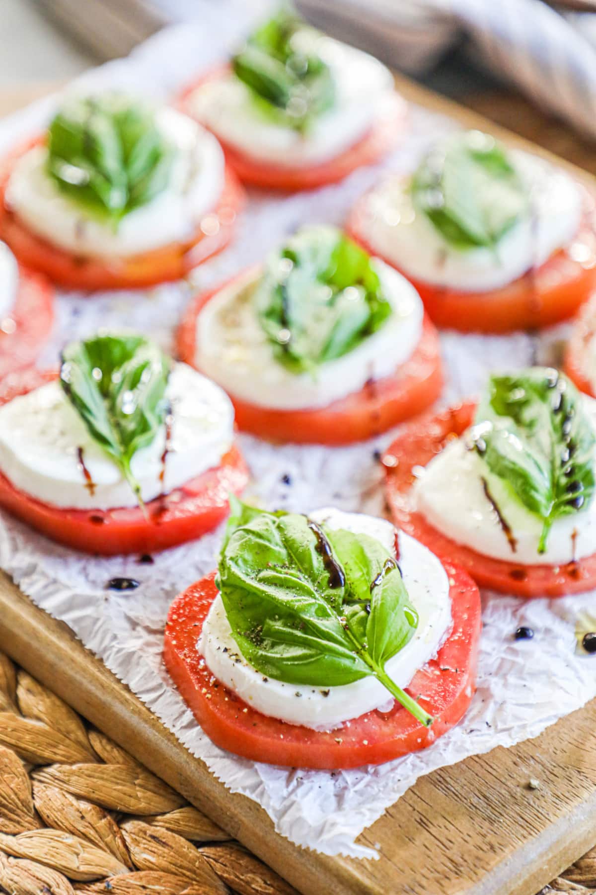 A picture of bruschetta - sliced tomatoes, a sliced of mozzarella and a piece of basil on top. 