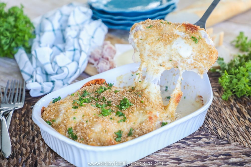 Chicken cordon bleu casserole being lifted from serving dish to plate.
