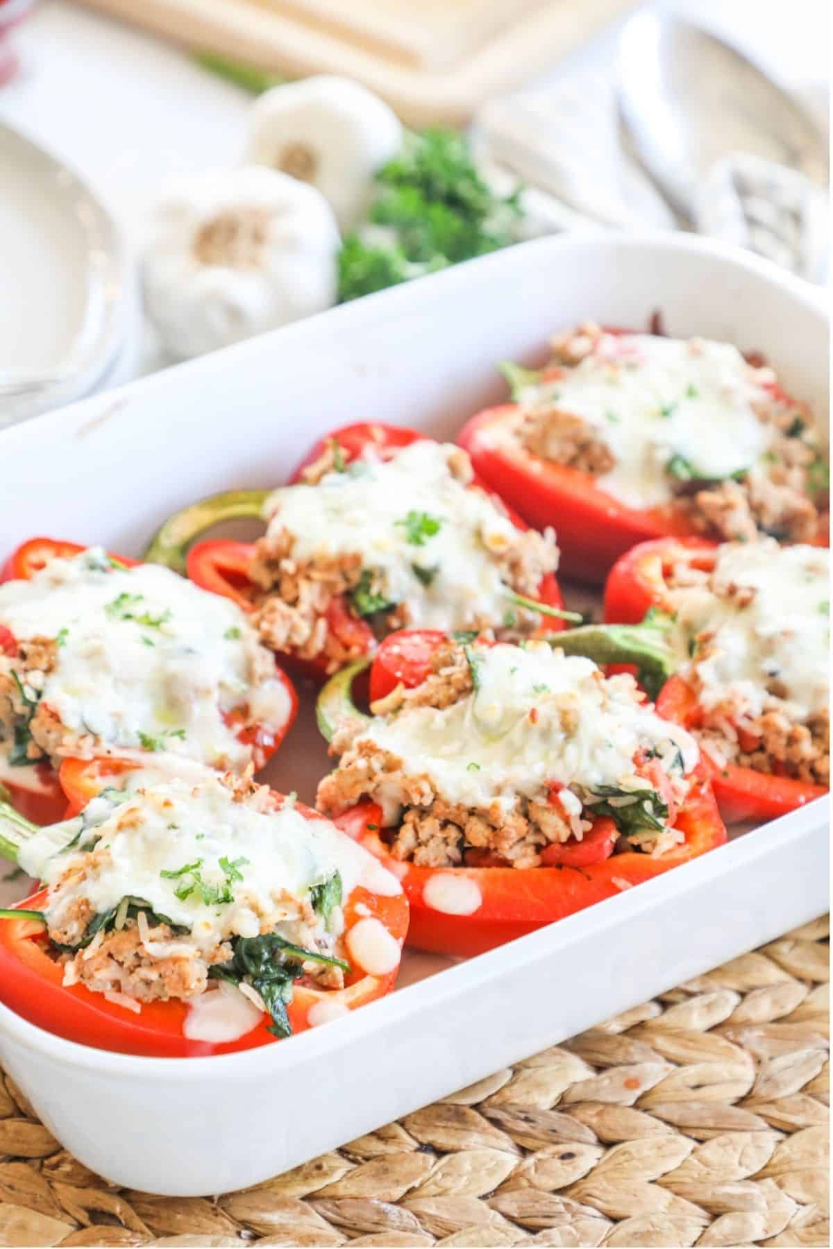 chicken stuffed peppers in a white casserole dish