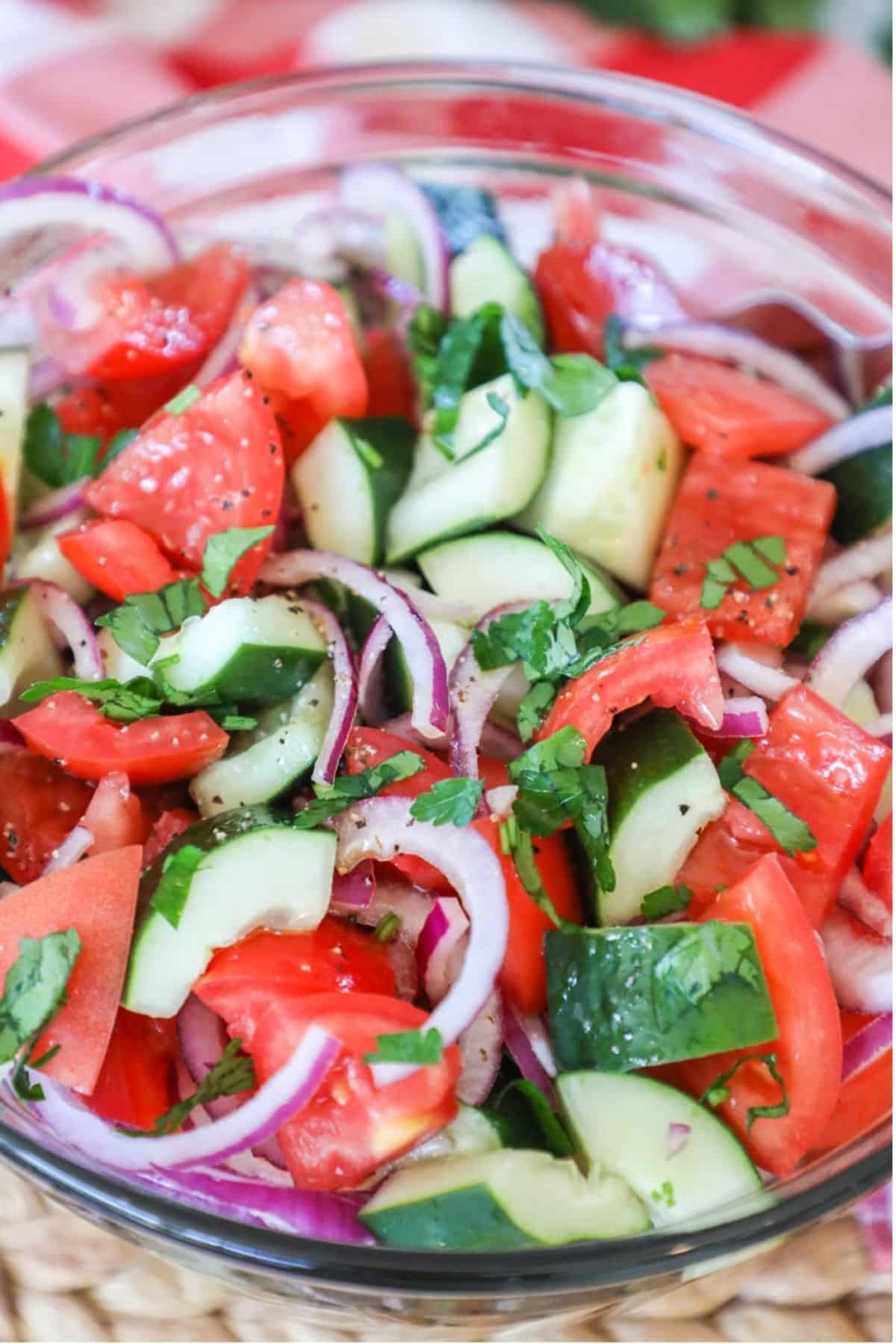 cucumber, red onion, tomato salad in a clear bowl