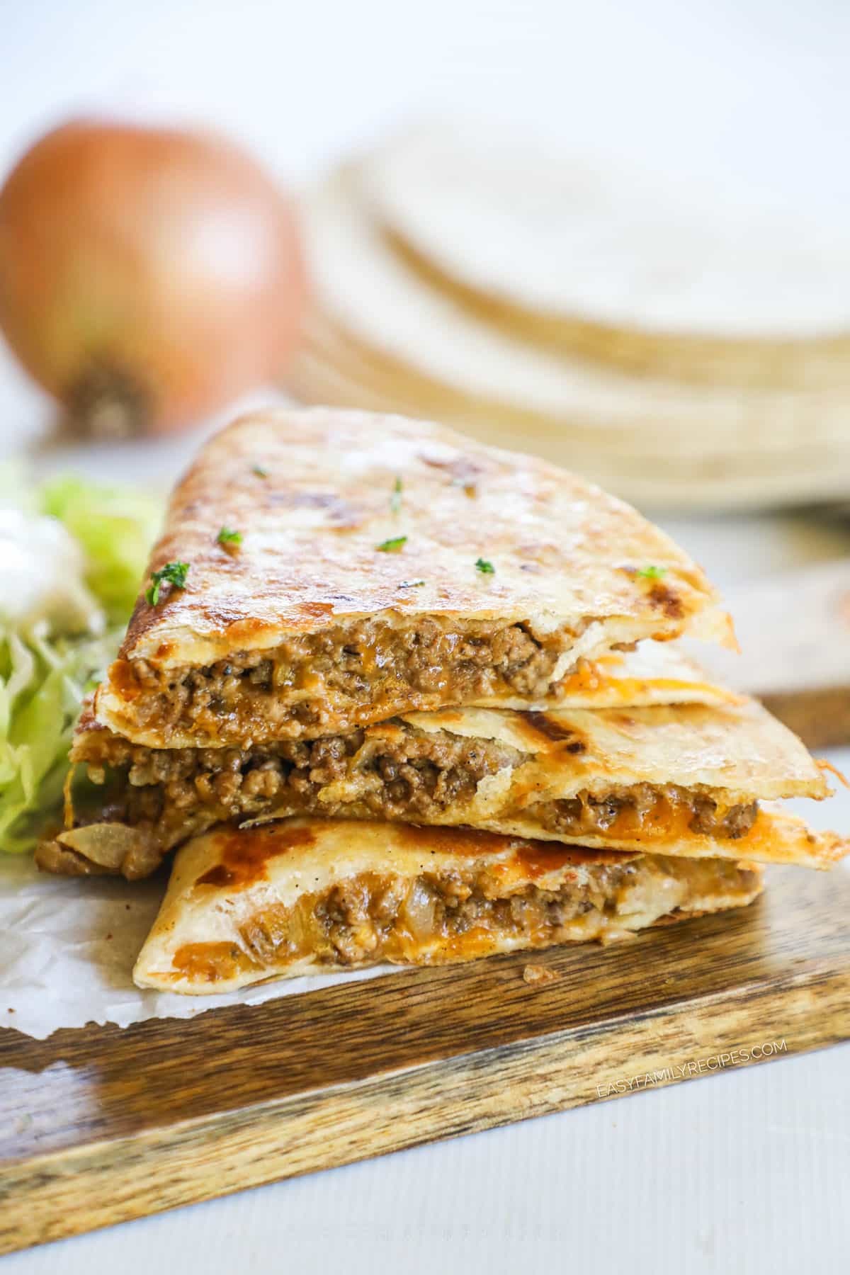 three slices of a ground beef quesadillas stacked.