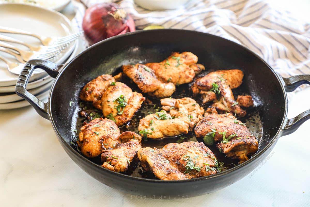 Photo showing Mexican Chicken Thighs in a cast iron skillet.