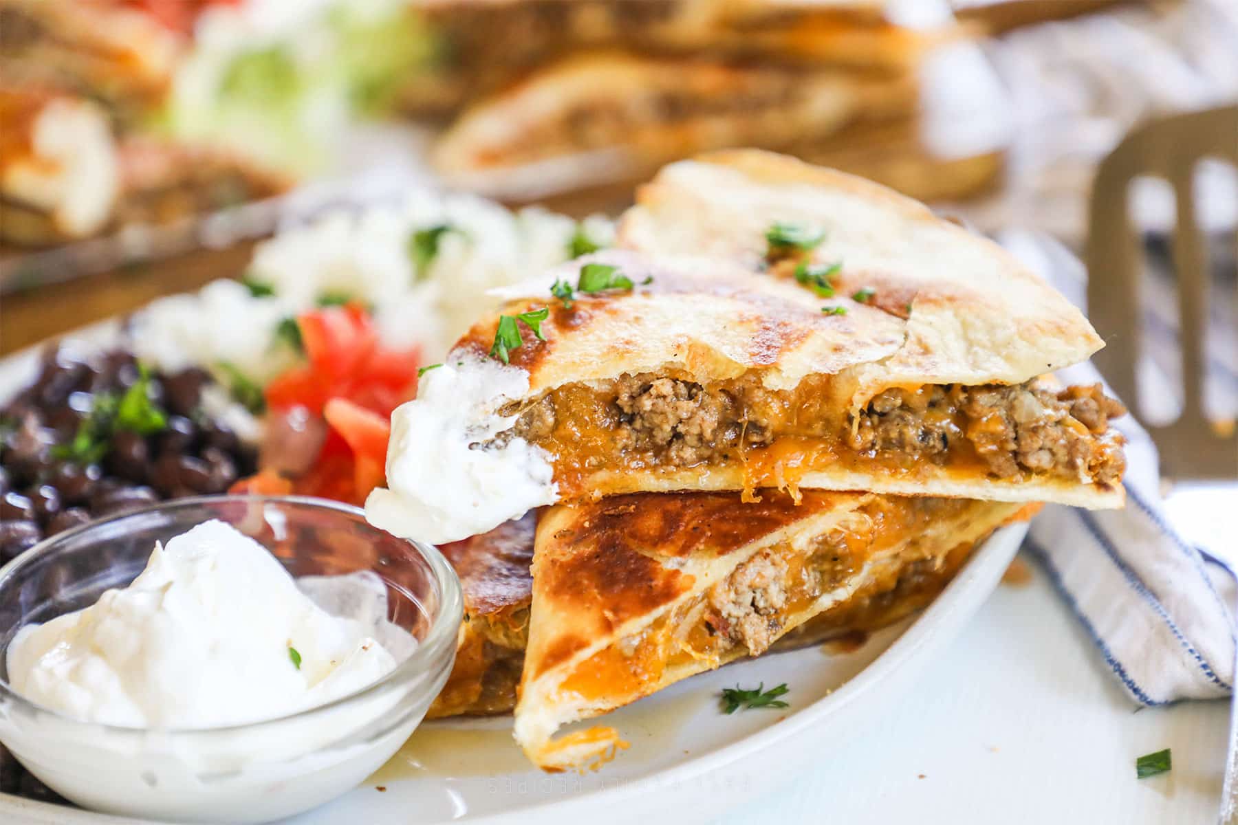 three slices of a ground beef quesadillas stacked.