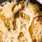 Smothered chicken breast in skillet with creamy gravy