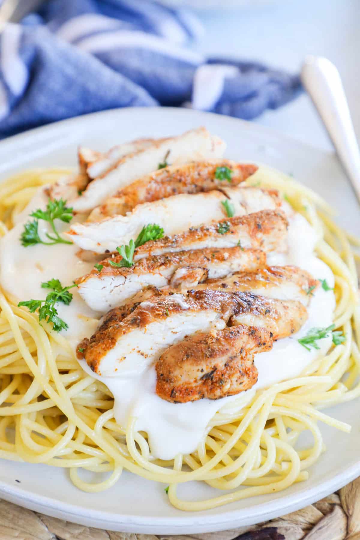 noodles with chicken on top and a white alfredo sauce