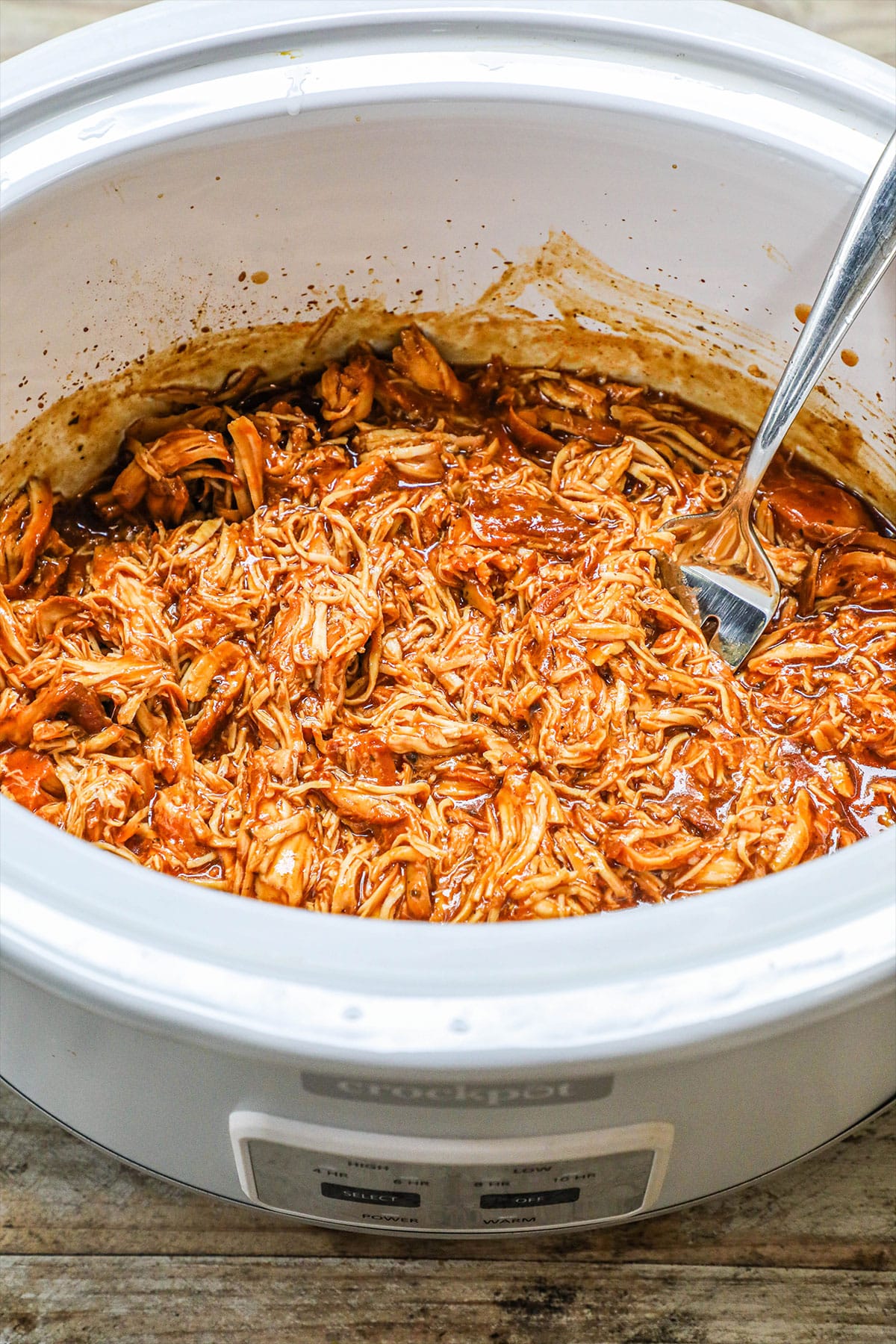 crockpot BBQ chicken in a white slow cooker