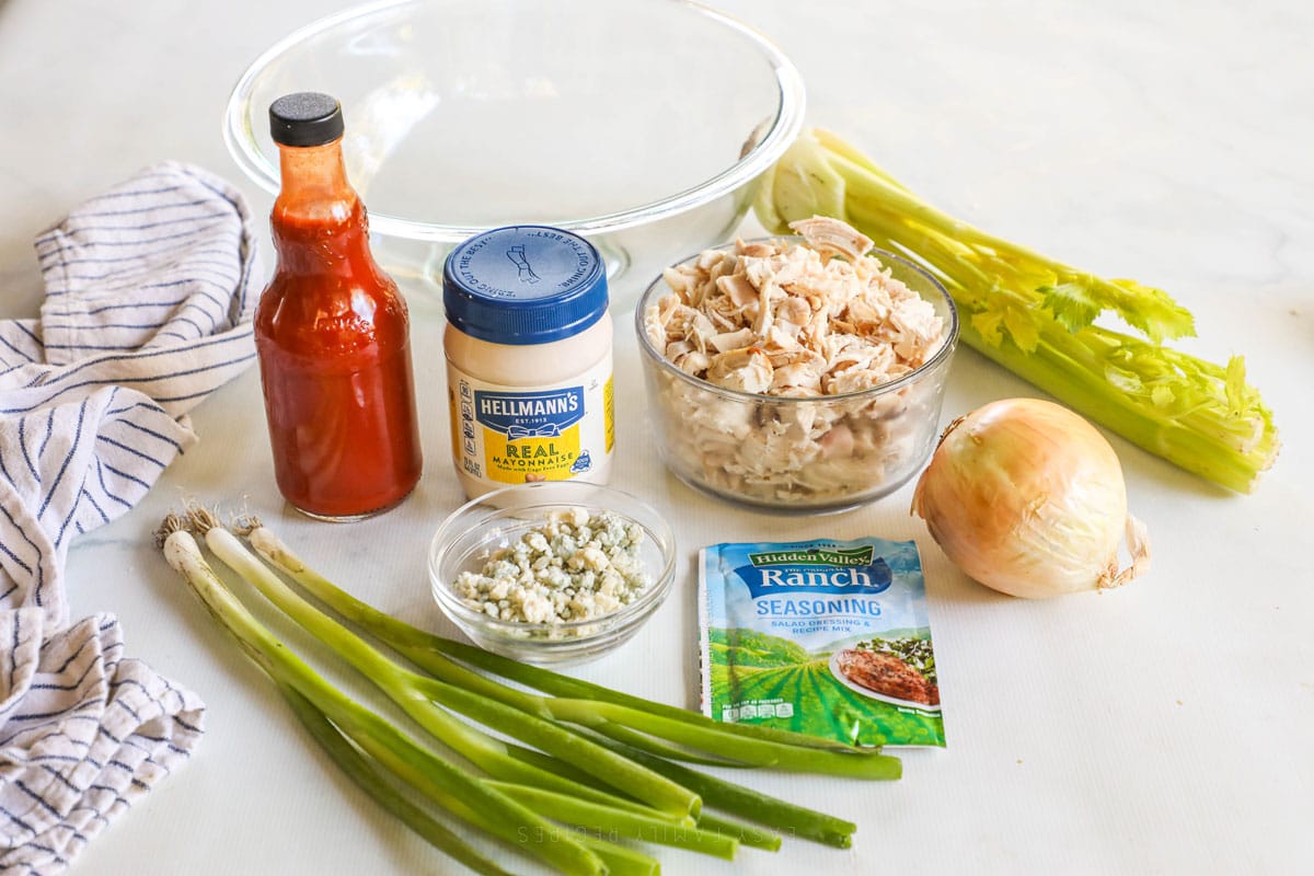 Ingredients for buffalo chicken salad include shredded chicken, buffalo sauce, mayo, veggies, and ranch seasoning.