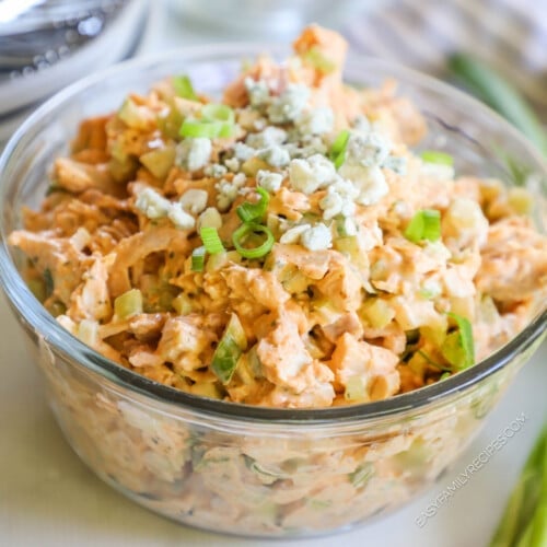 A bowl of buffalo chicken salad with blue cheese crumbles on top.