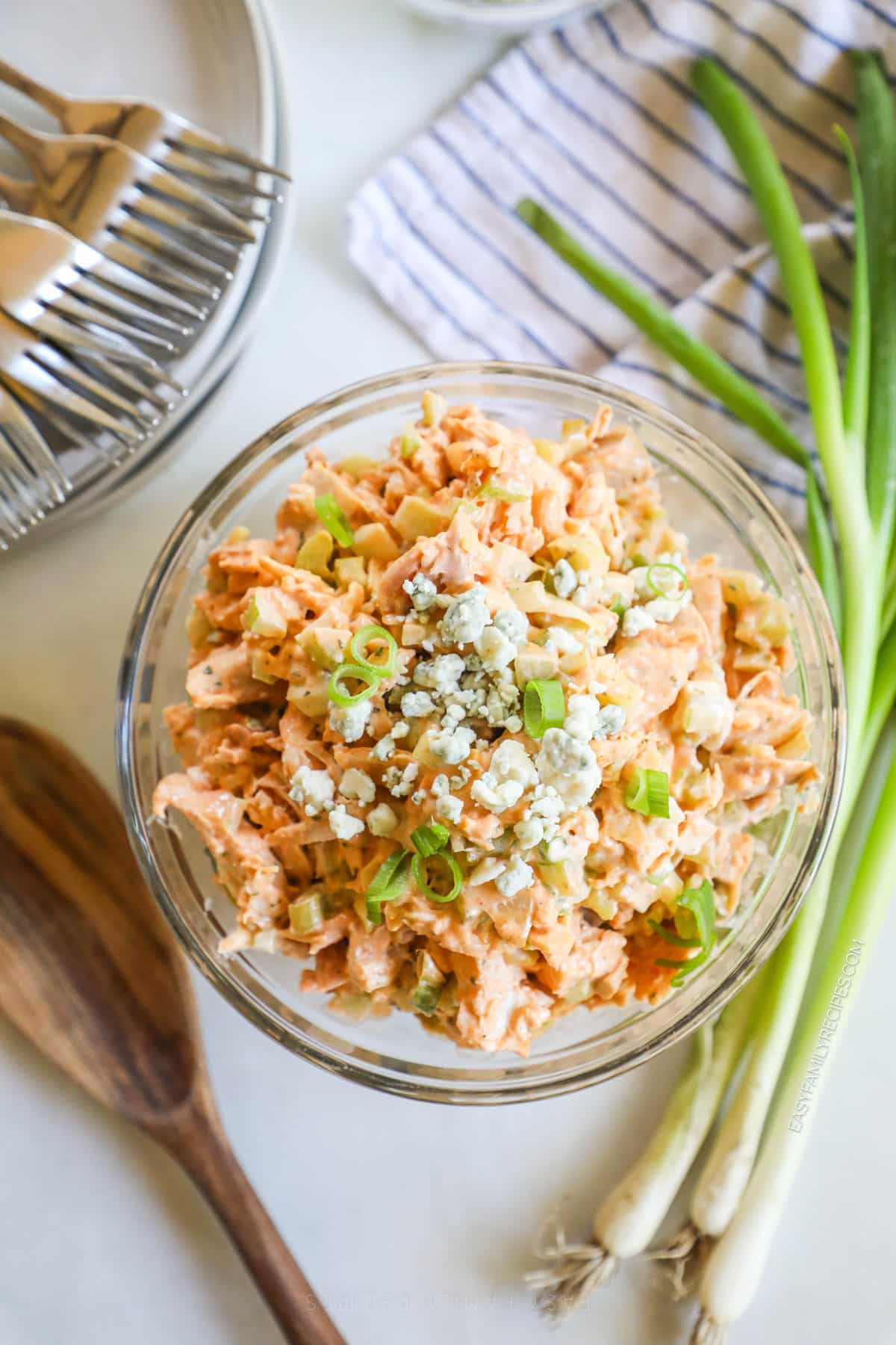 A bowl of buffalo chicken salad with blue cheese crumbles on top. 