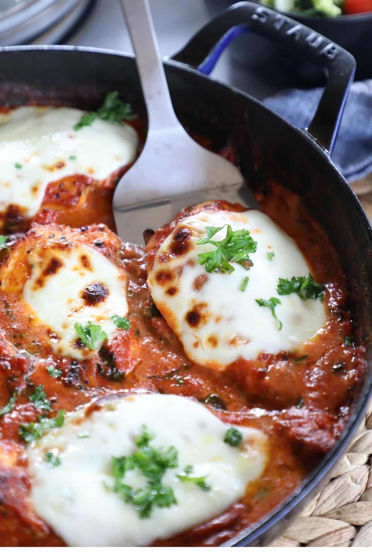chicken breasts with tomato sauce and cheese in a skillet