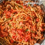 Pot of ground turkey spaghetti tossed in the sauce with chunks of tomatoes and fresh herbs.