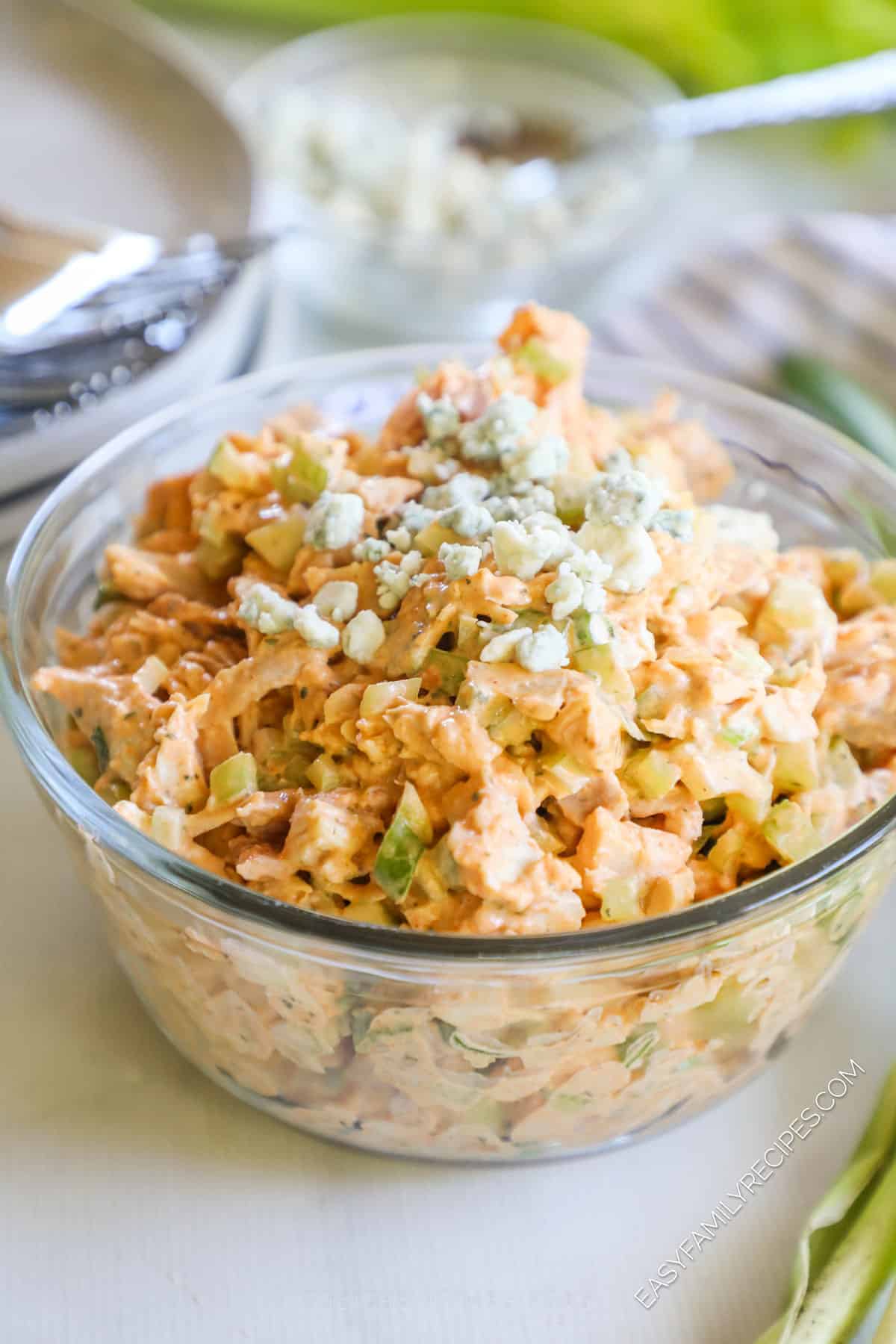 buffalo chicken salad in a bowl, topped with blue cheese crumbles