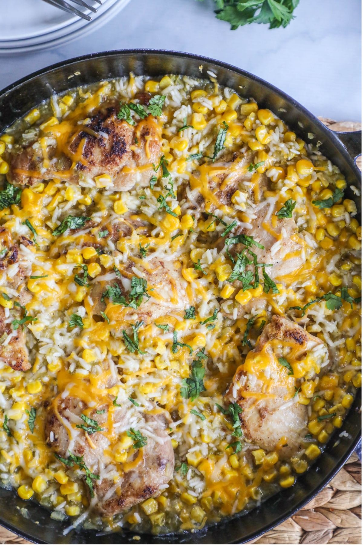 chicken thighs with rice, corn, salsa in a skillet
